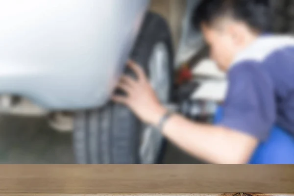 Автомеханик в мастерской меняет шины или диски (размытое изображение) — стоковое фото