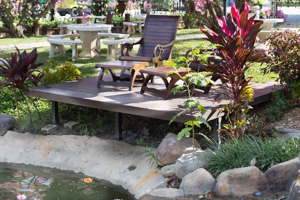 Två bord och stolar bredvid dammen i trädgården — Stockfoto