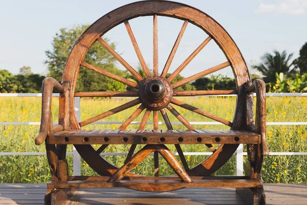 Holzstuhl mit Wagenrad auf der Terrasse in Sonnenhanf-Pumme dekoriert — Stockfoto