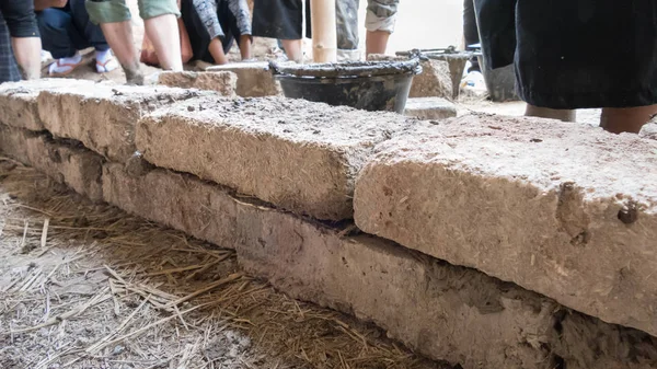 Group of young people earth building the wall of earthen house — Stock Photo, Image