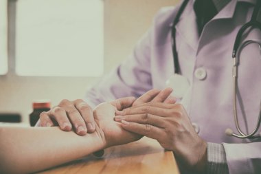 Doktor elleri kadın bileğinde nabız hissediyor.