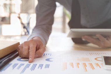 Çizelgeler ve grafikler dijital tablet ile analiz işadamı.