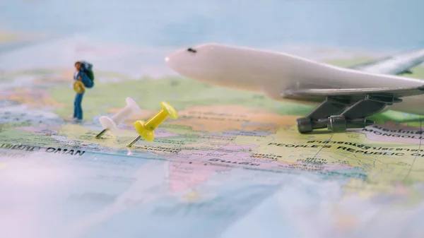 Traveler miniature mini figure with backpack walk on world map w