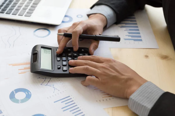 Empresário analisando relatório no gráfico com calculadora — Fotografia de Stock