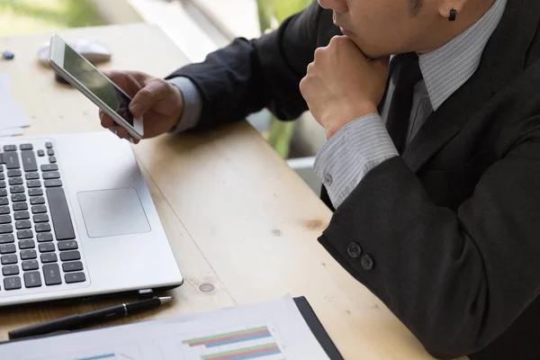 Empresário analisando gráficos e gráficos com smartphone e comp — Fotografia de Stock