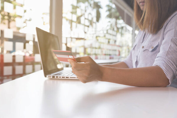 woman holding credit card with laptop computer for online shoppi