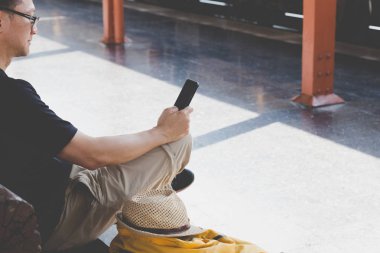 Trende sırt çantası ile istasyonu platformu üzerinde bekleyen genç adam