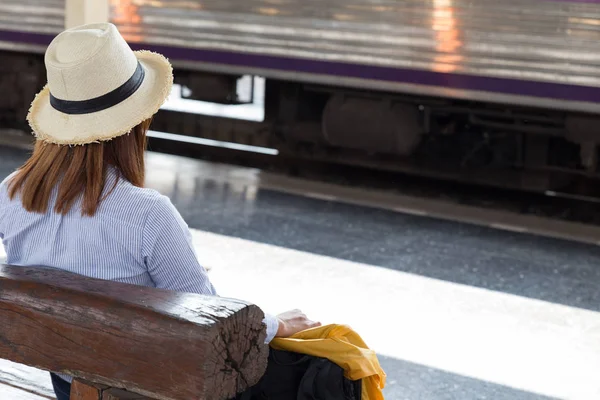 Ung kvinna väntar på perrongen med ryggsäck på tra — Stockfoto