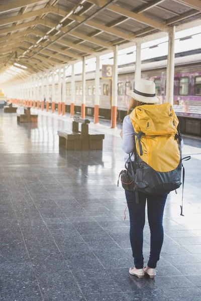 Jonge vrouw te wachten op het perron van het station met rugzak op tra — Stockfoto