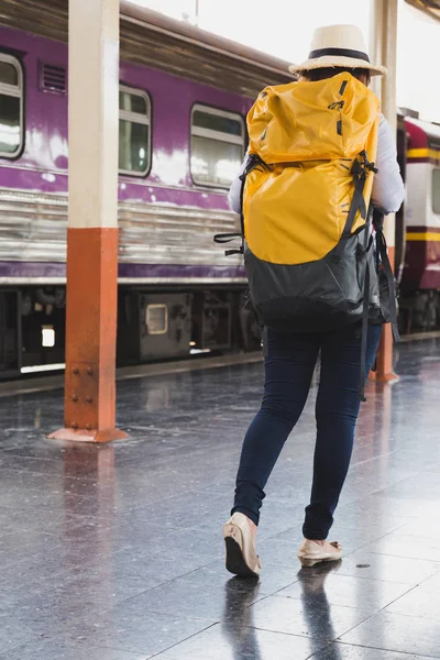 Jonge vrouw te wachten op het perron van het station met rugzak op tra — Stockfoto