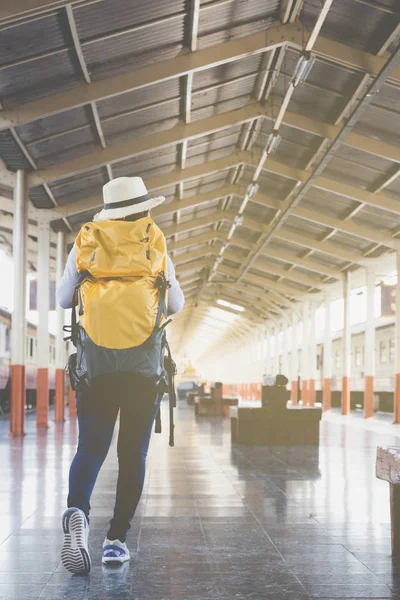 Jovem esperando na plataforma da estação com mochila no tra — Fotografia de Stock