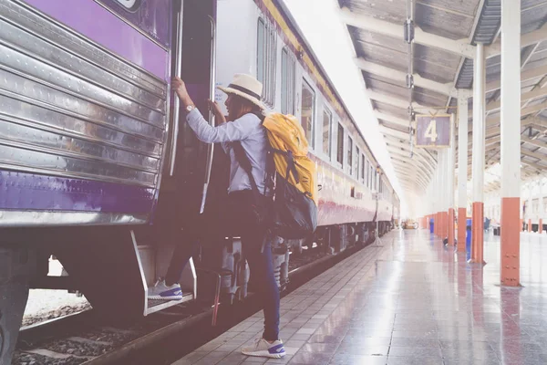 Девушка-путешественница с рюкзаком поднимается в поезд одна. travel jour — стоковое фото