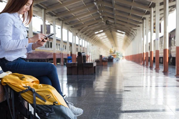 Jonge vrouw te wachten op het perron van het station met rugzak op tra — Stockfoto