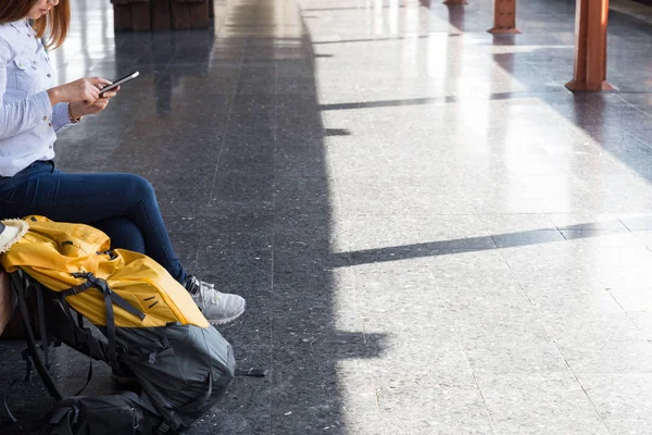 Jonge vrouw te wachten op het perron van het station met rugzak op tra — Stockfoto