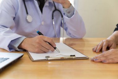 Doktor kadın hastasına teşhis koyuyor. Hekim ver.