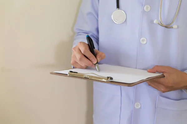 medical doctor man with a pen writing on clipboard. Medical care