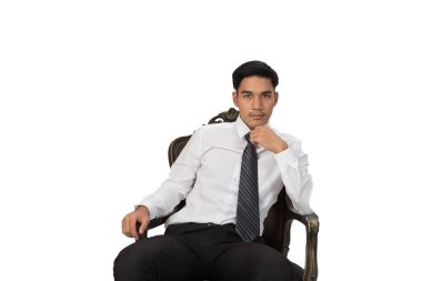 Sandalyede oturan ve üzerinde poz beyaz gömlek giymiş işadamı