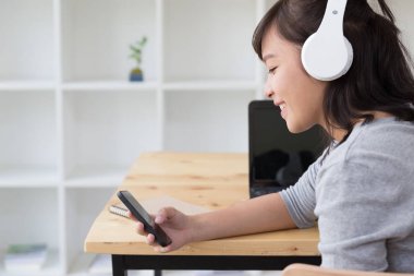 Asyalı kız kadın genç öğrenci kulaklık ve dinle