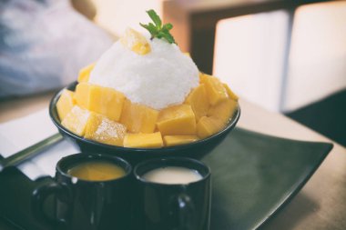 Mango sy ile hizmet veren siyah plaka üzerinde taze Mango ile kesilmiş buz