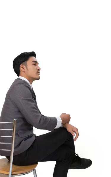 Empresário vestindo terno cinza sentado na cadeira e pensando sobre — Fotografia de Stock
