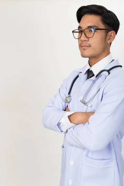 Sonriente joven doctor masculino con estetoscopio y brazos cruzados —  Fotos de Stock