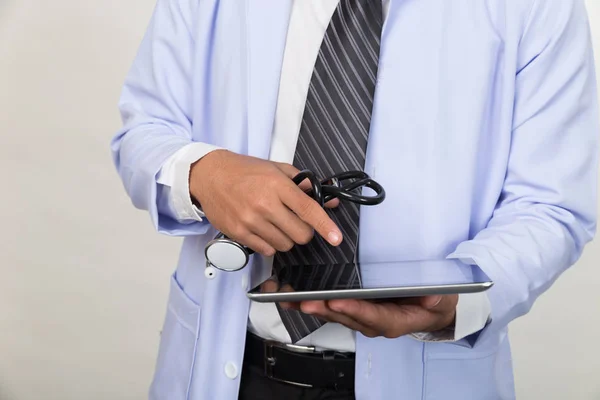 Arzt hält Stethoskop in der Hand und arbeitet mit modernem Tabl — Stockfoto