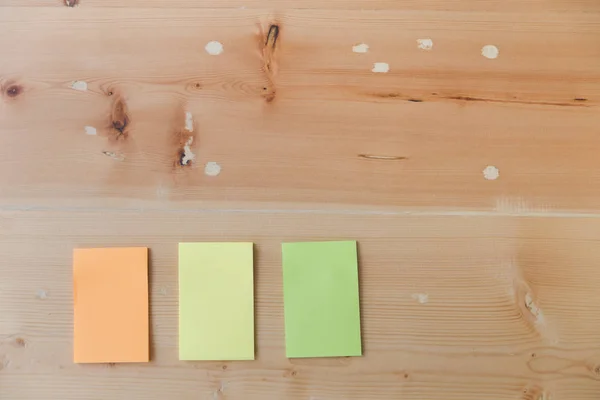 Flat lay of office supplies - colorful sticky notes on wooden bo — Stock Photo, Image