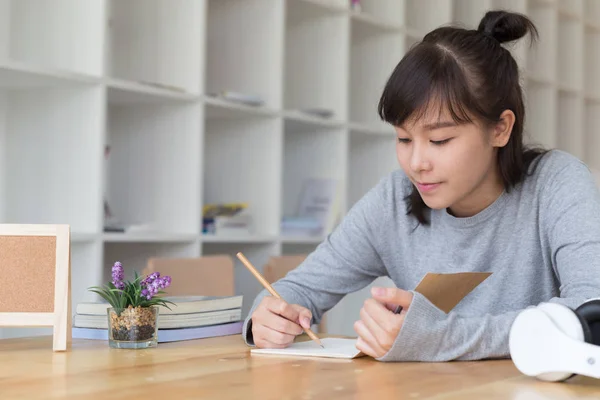 Asyalı kız kadın genç okulda okuyor. Öğrenci yazı n