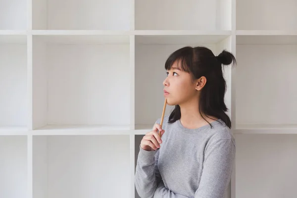 Asyalı kız kadın genç öğrenci boo yanında bir şey düşünüyor