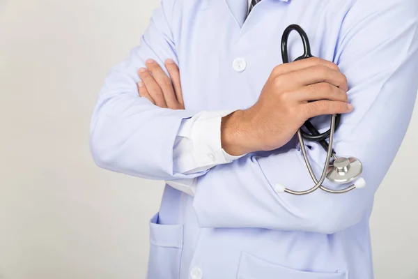 Joven doctor, médico sosteniendo su estetoscopio en la mano con el brazo — Foto de Stock