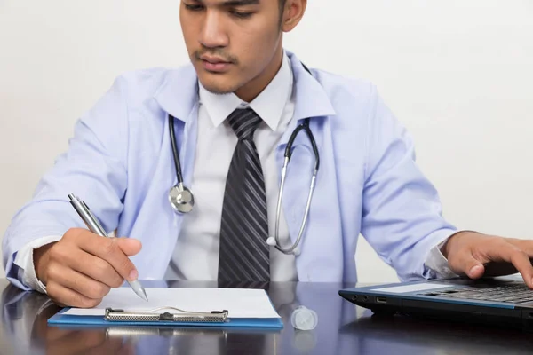 doctor writing RX prescription in medical office clinic on desk,