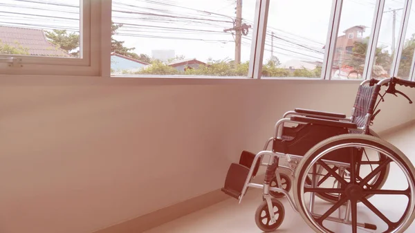 Wheelchair parked in hospital hallway beside window — Stock Photo, Image