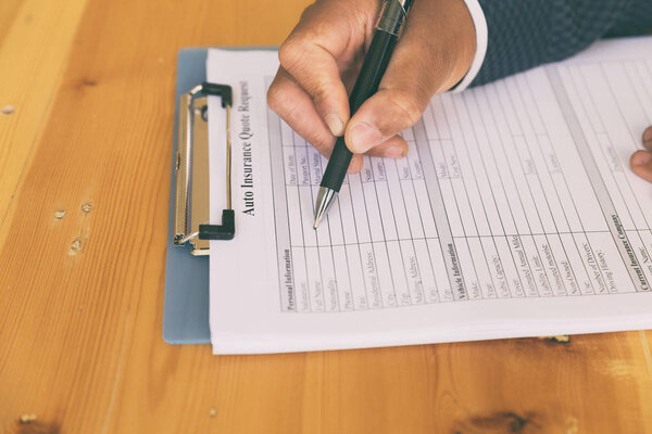 hand fill out auto insurance form on a clipboard - Car Motor Rei