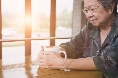 oturma ve kafeterya kahvehane ile dinlenme Asyalı yaşlı kadın
