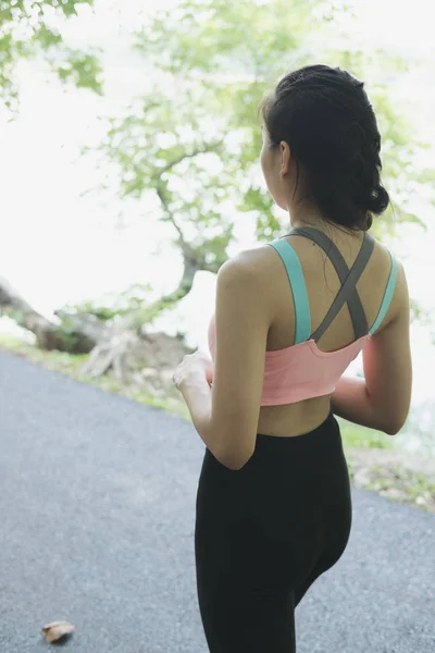 Female sport fitness runner jogging outdoors in spring or summer