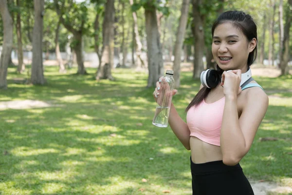 若い美しいアジアのフィットネス選手女性飲酒ワットを保持 — ストック写真