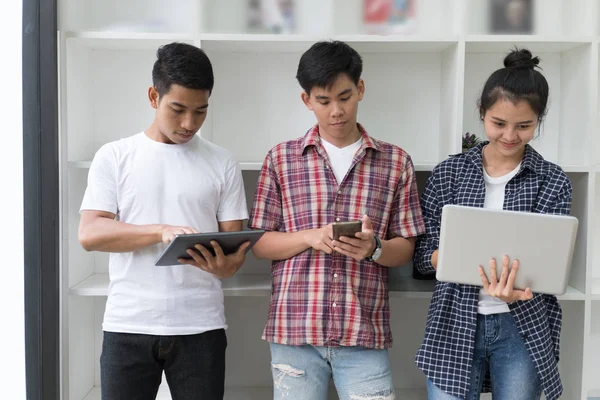 Jóvenes asiáticos están utilizando diferentes gadgets y sonriendo, stan — Foto de Stock