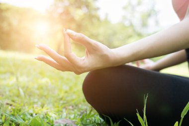 Yogada yaz park açık havada. genç kadın lotus bulunduğu oturur