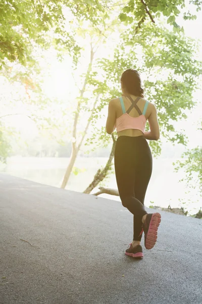 Female sport fitness runner jogging outdoors in spring or summer