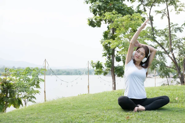 Aziatische zwangere vrouw terwijl u luistert naar muziek op het beoefenen van yoga — Stockfoto