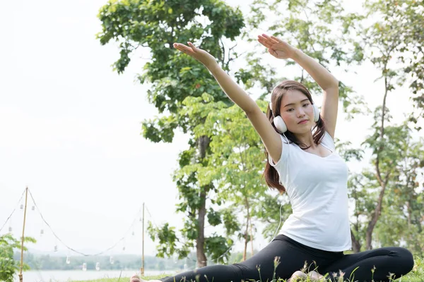 Asiatique enceinte femme pratiquant yoga tout en écoutant de la musique sur — Photo