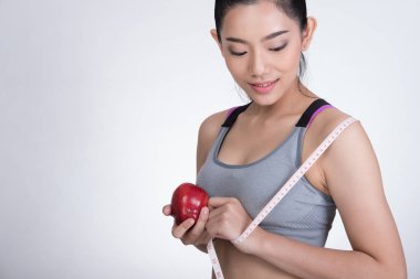 Teyp ve Kırmızı elma ayakta ölçme ile sportif fitness kadın 