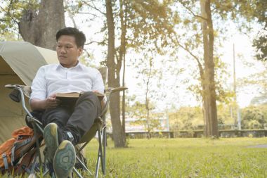 sandalye ve okuma kitabı önünde oturan genç adam turizm 