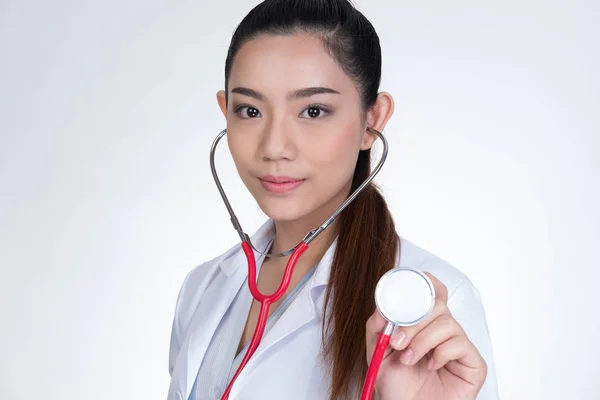 Médico feminino mostrando estetoscópio para check-up sobre backgro branco — Fotografia de Stock