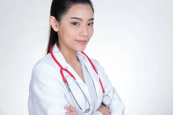 Fiducioso sorridente giovane medico femminile in posa con le braccia incrociate . — Foto Stock