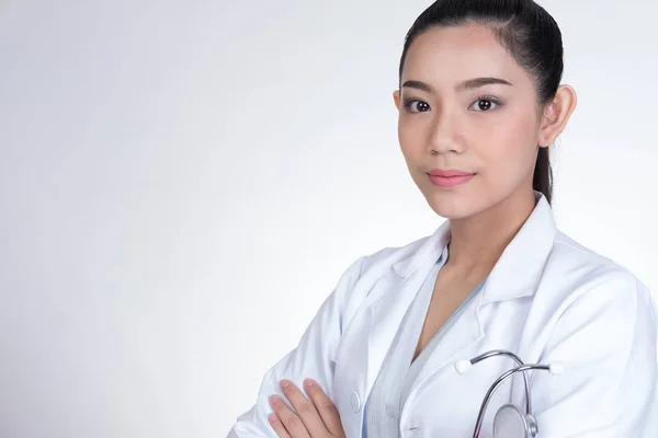 Fiducioso sorridente giovane medico femminile in posa con le braccia incrociate . — Foto Stock