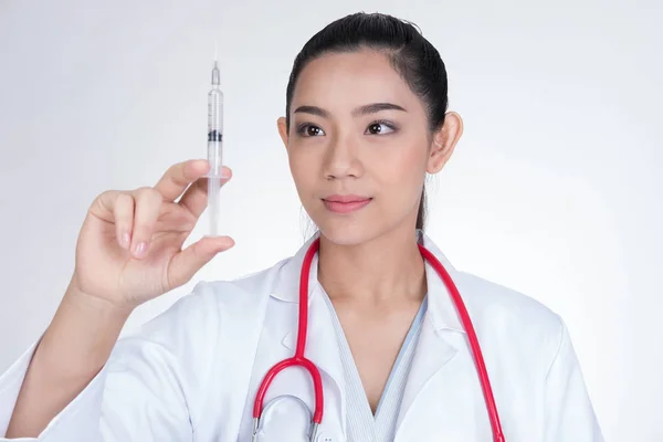 Selbstbewusst lächelnde Ärztin mit einer Spritze in der Hand. Porträt — Stockfoto
