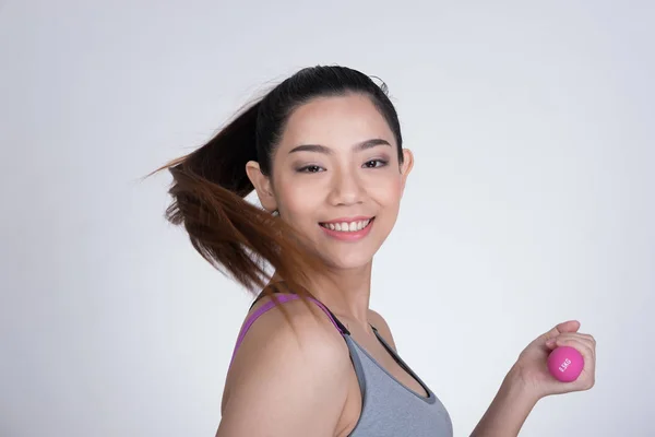 Молода азіатська спортивна жінка тренується з гантелі. Гарненький атлет — стокове фото