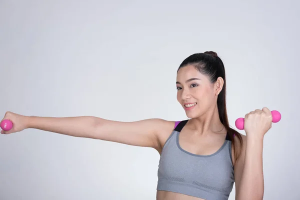Молода азіатська спортивна жінка тренується з гантелі. Гарненький атлет — стокове фото