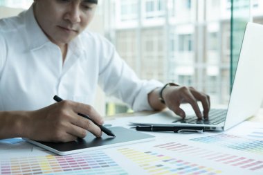 bilgisayar ve renk renk örneği ile çalışan genç grafik tasarımcı. c